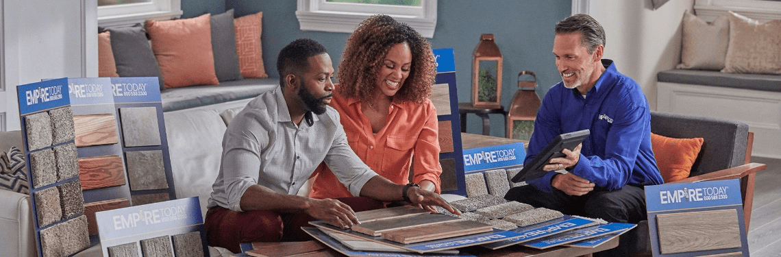 couple viewing different sample flooring boards in their home