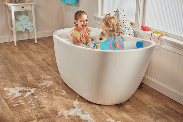 two girls playing in the bathtub in a bathroom with waterproof laminate flooring